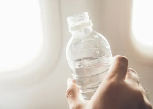 hand holding water bottle on airplane